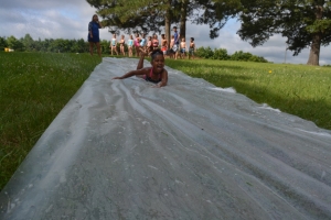 A child takes a ride on the water slide this morning.