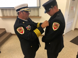 Clements pins his son&#039;s badge on his uniform.